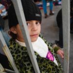 Am Hafen von Lesbos, kleines Mädchen hinter einer Absperrung