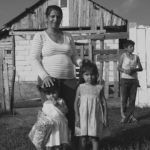Mariana and her children in front of their house